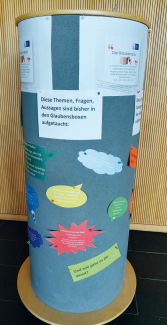Litfaßsäule mit Fragen aus der Glaubensbox