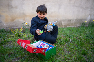 Kind packt ein Weihnachtspäckchen der Spendenaktion aus.